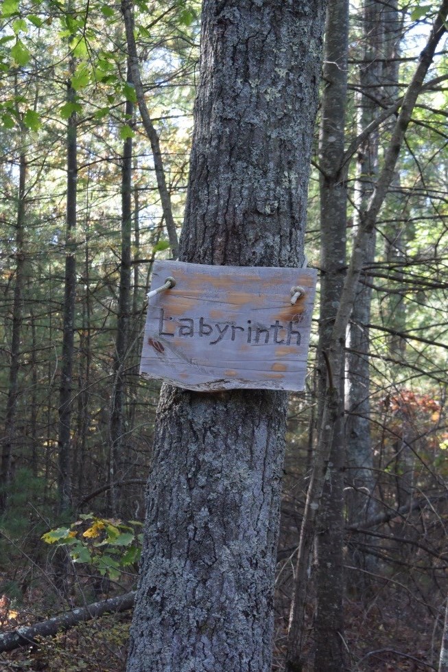 A carved wooden sign near the entrance to the labyrinth